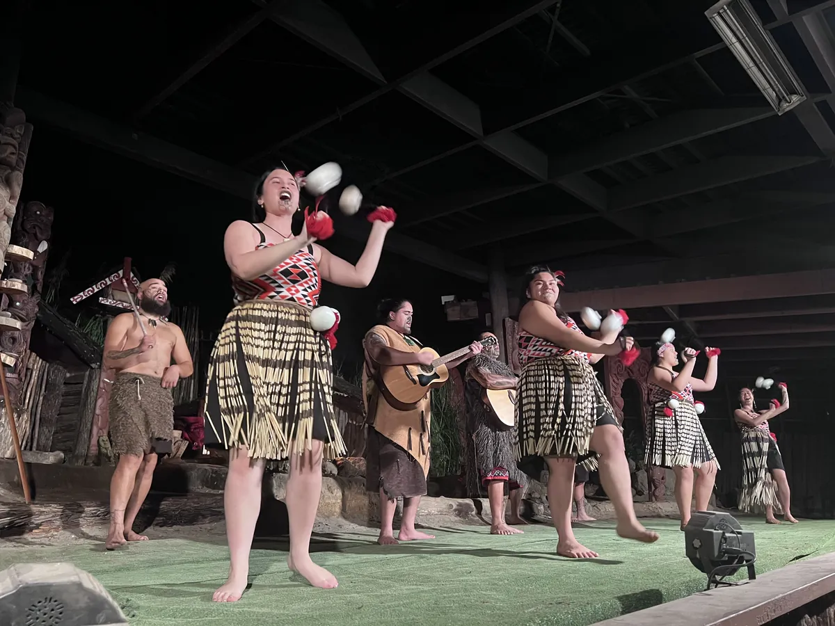 A Māori performer in traditional dress spinning poi during a cultural performance